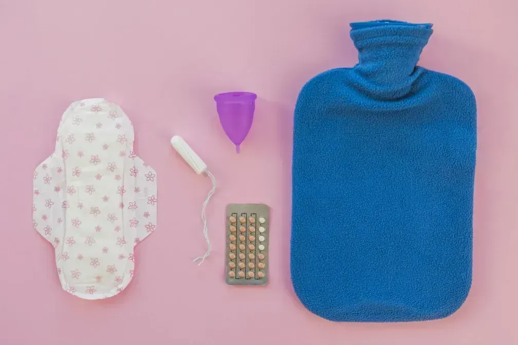 starke Periode: Menstruationsprodukte wie Binde, Tampon, Menstruationstasse, Wärmflasche und Medikamente bei starker Regelblutung