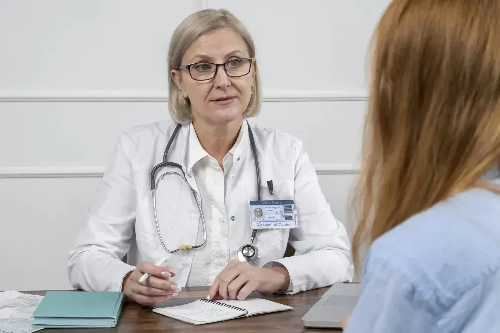Ärztin im Gespräch mit Patientin in der Praxis – medizinische Beratung und Aufklärung über mögliche Schmemrzen beim Eisprung