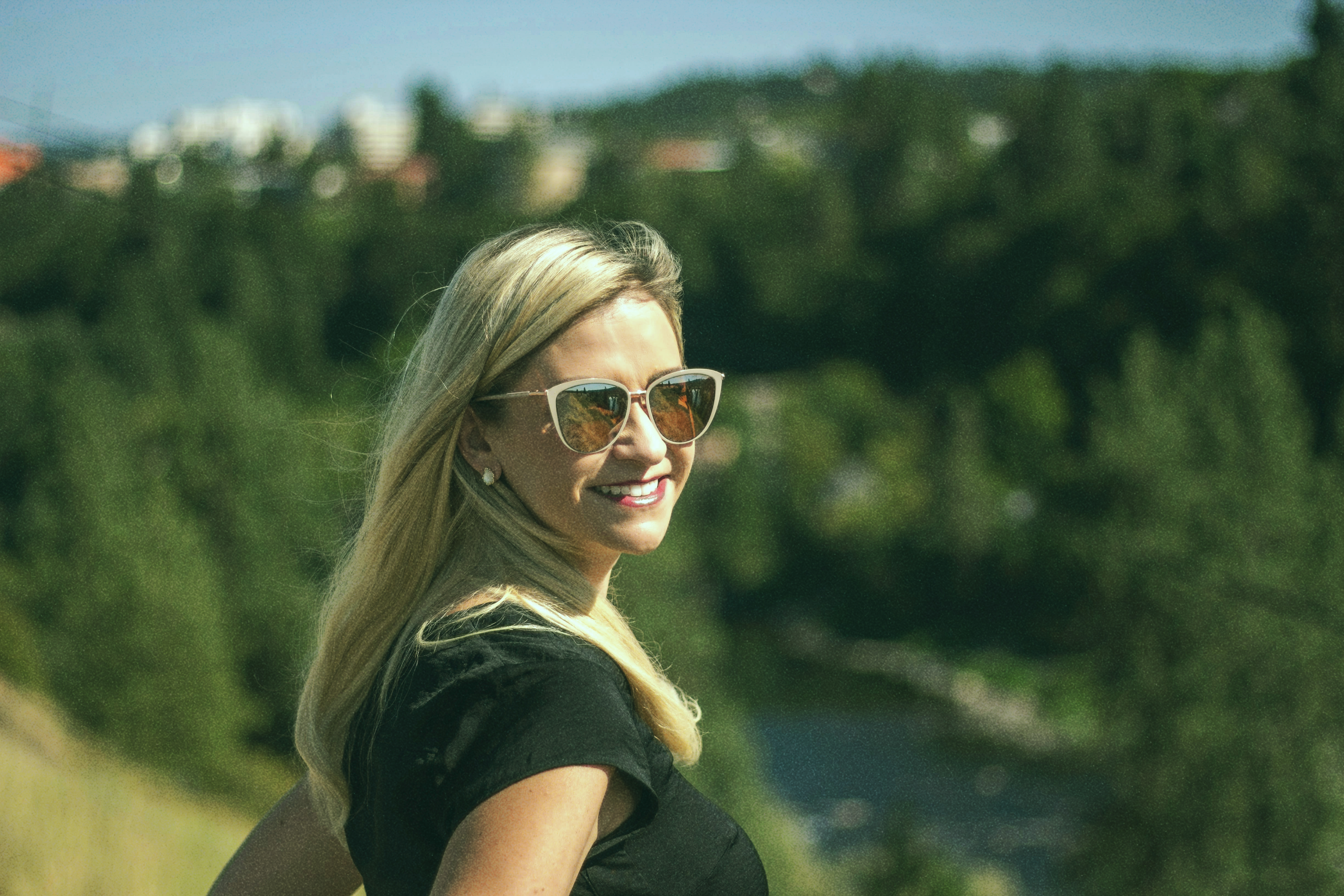 Blonde woman smiling with trees in the background