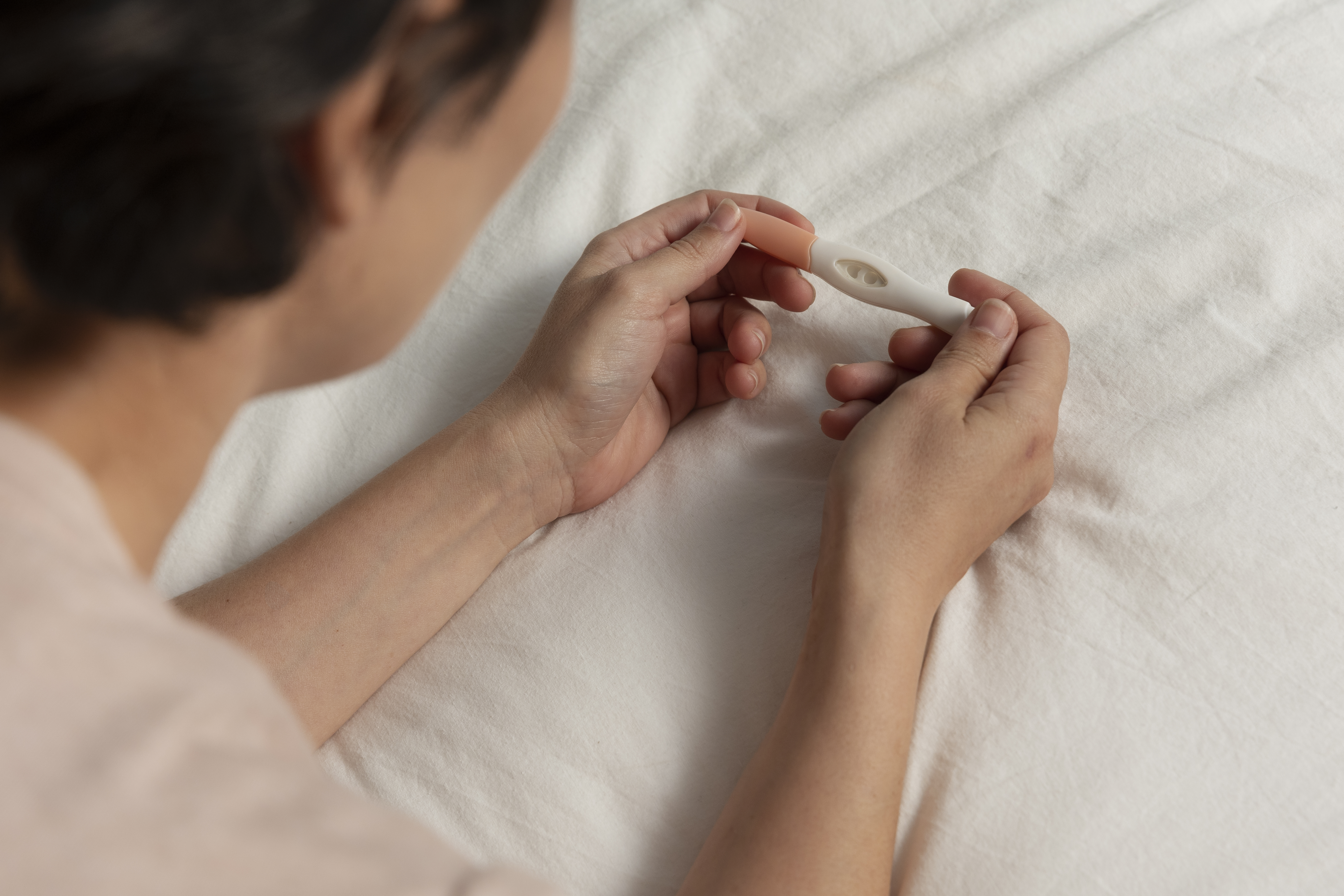 Woman experiencing mild cramping at 6 DPO, a common early symptom during the two-week wait